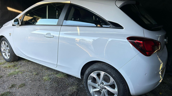white hatchback car parked on gravel with sleek design and six efficient features